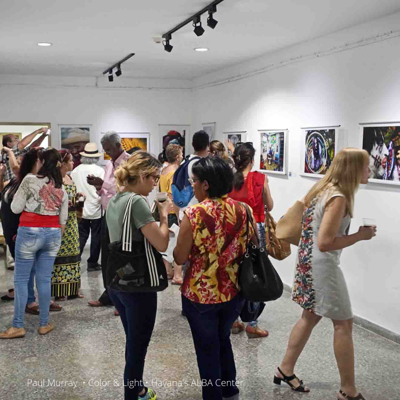 group of people viewing photo exhibit inside of an art gallery